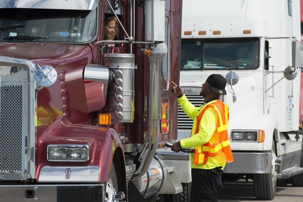 A man speaking with a truck driver.